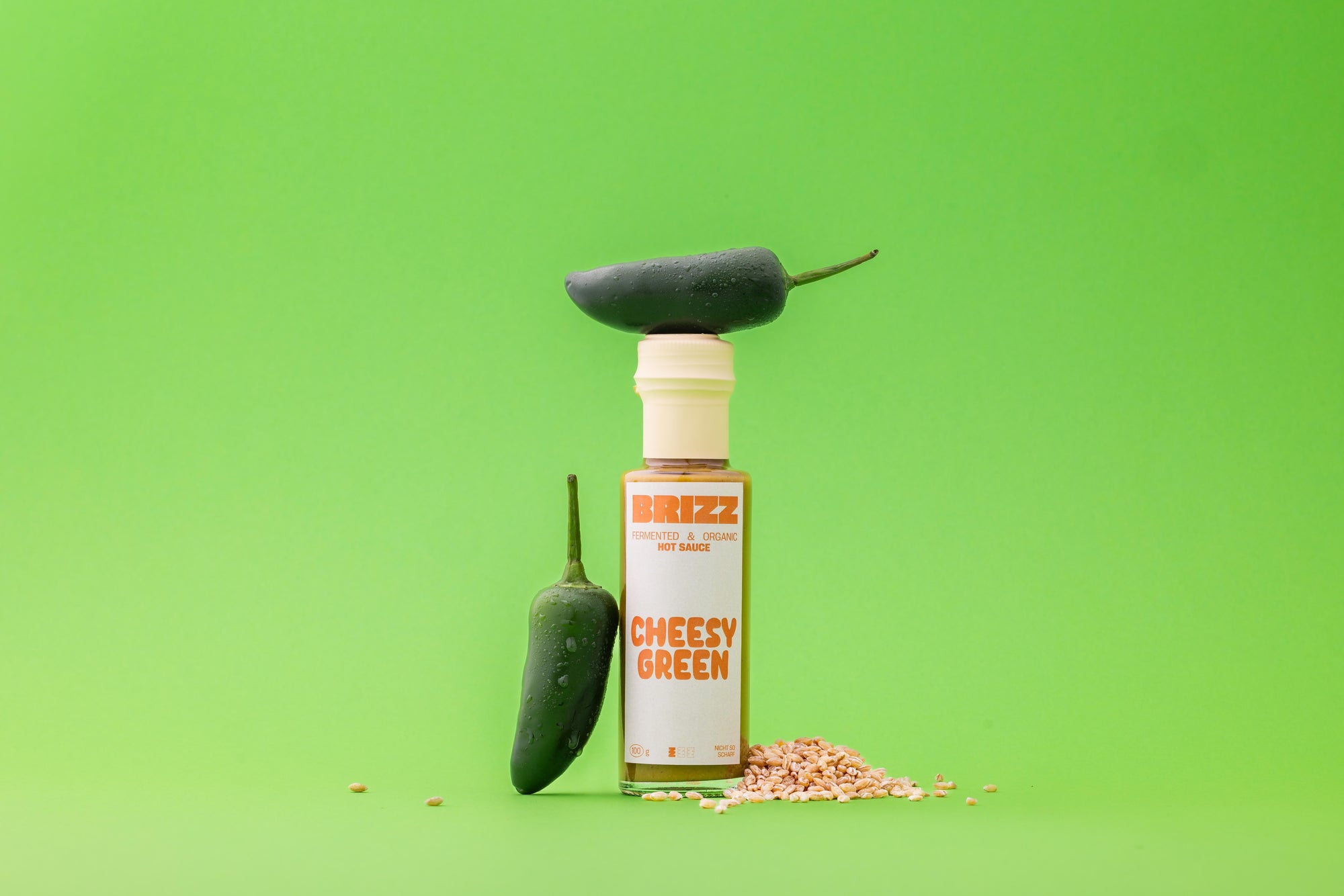 BRIZZ Cheesy Green Sauce – fermentierte Bio-Joghurt-Sauce mit Jalapeño und Koji auf grünem Hintergrund.