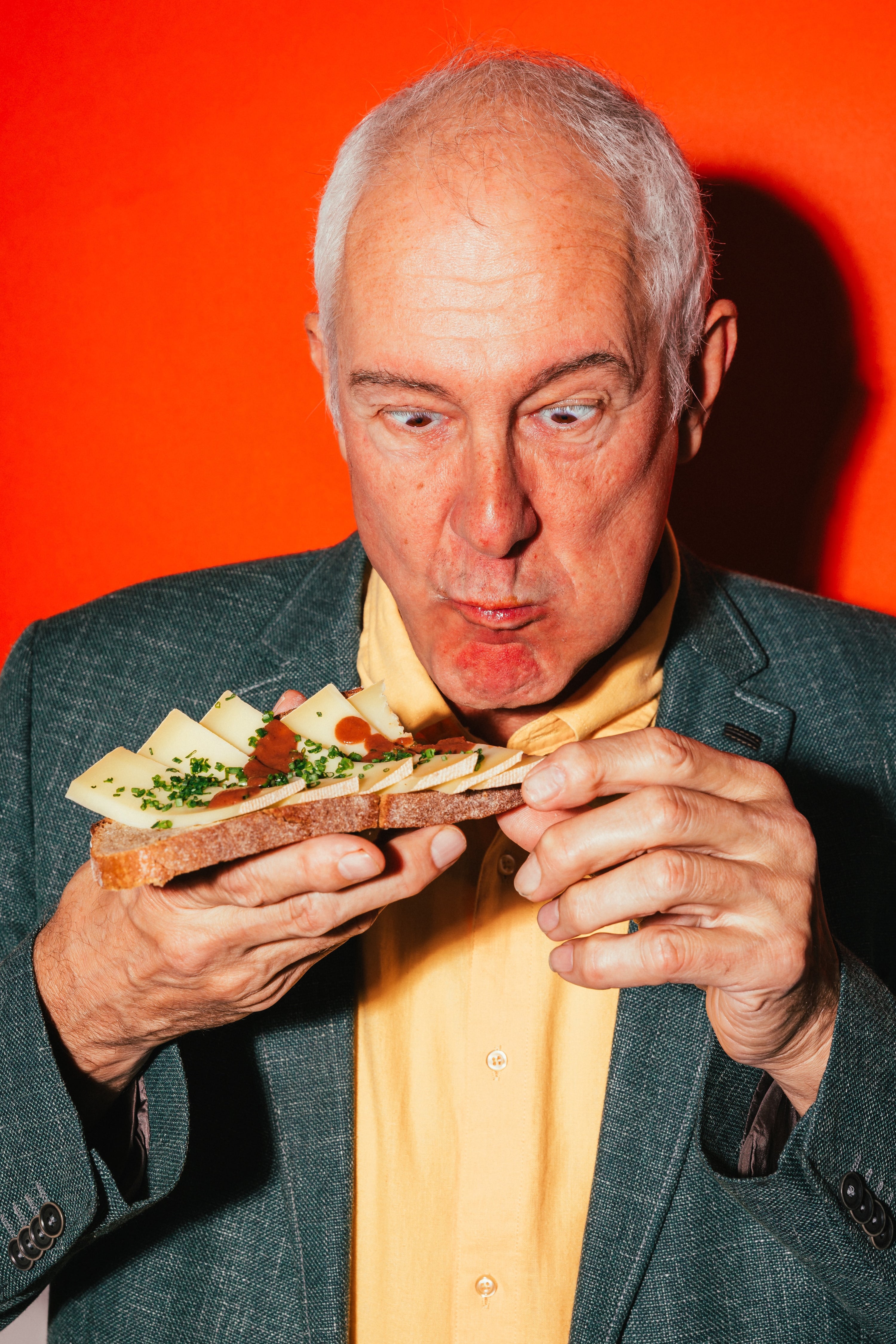 Älterer Mann genießt Sandwich mit BRIZZ Climax Hot Sauce – intensiv, scharf und fruchtig.