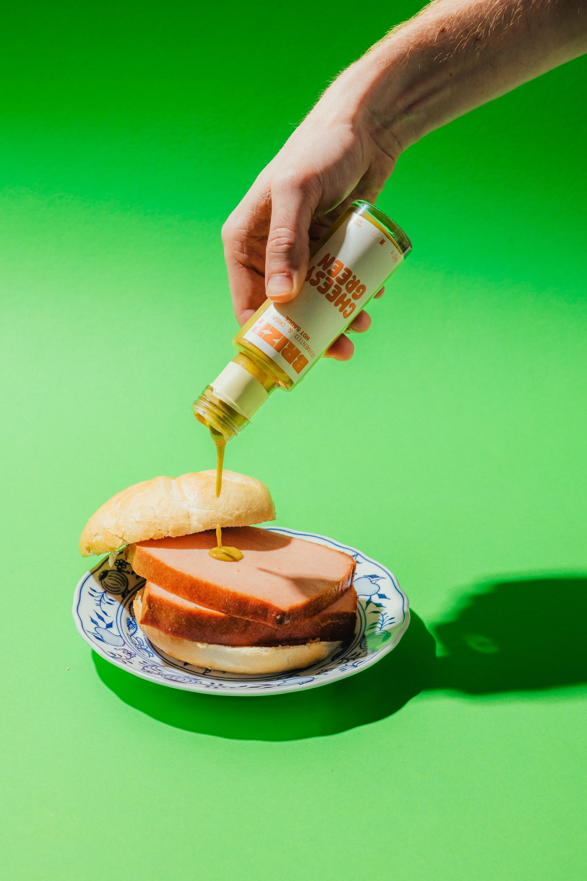 BRIZZ Cheesy Green Sauce wird über Leberkäse gegossen – cremig, mild, fermentiert.