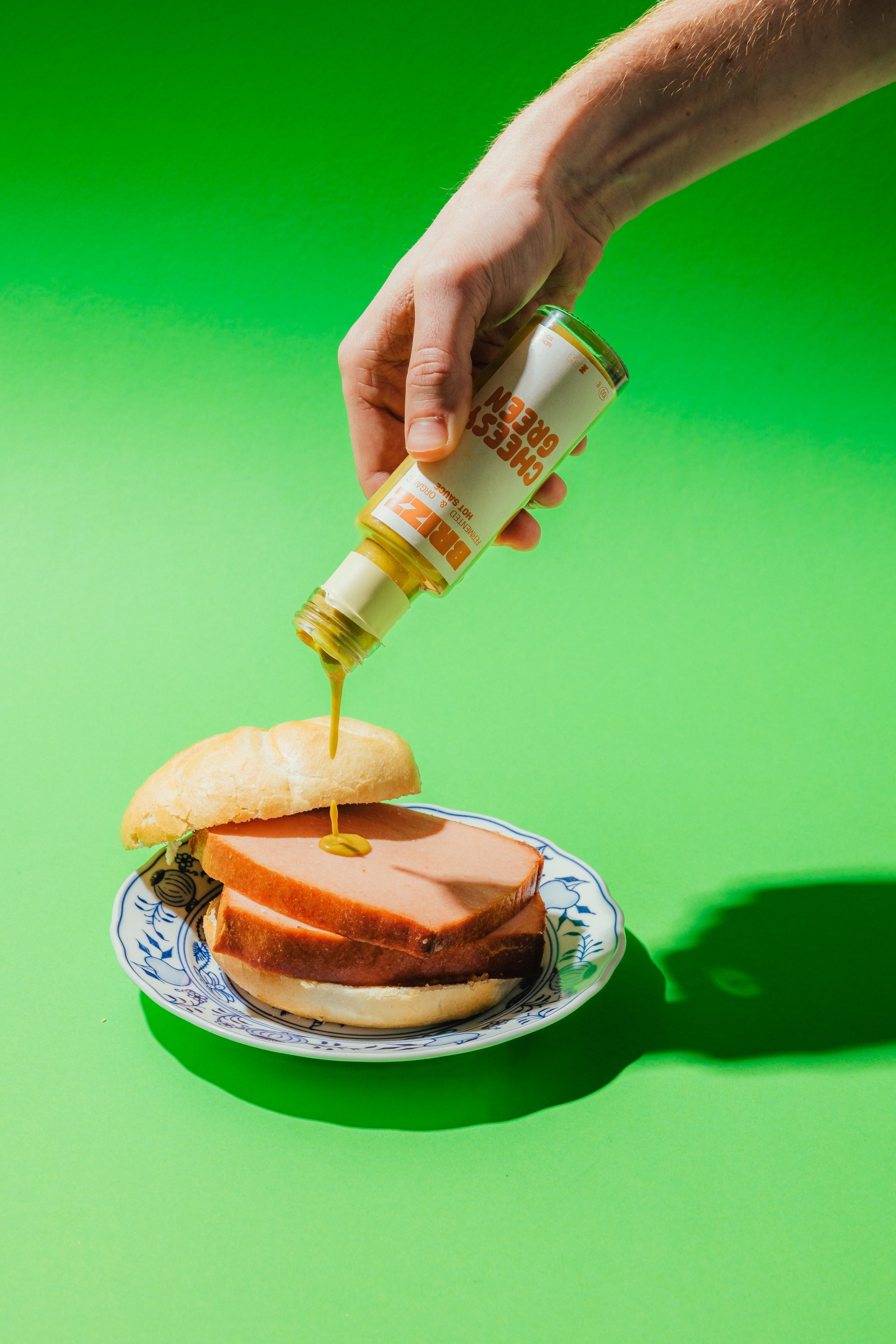 BRIZZ Cheesy Green Sauce wird über Leberkäse gegossen – cremig, mild, fermentiert.