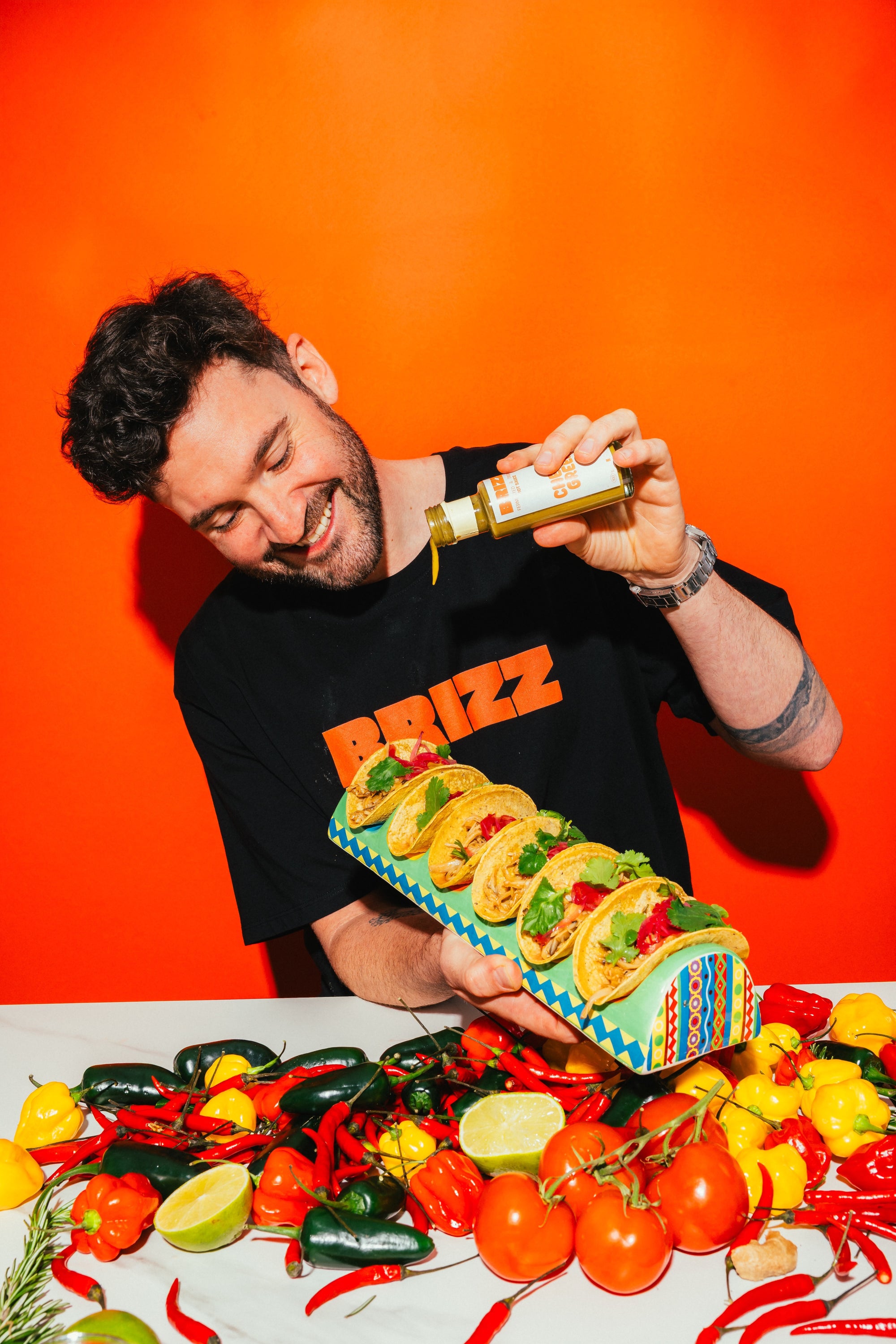 Johannes Schartner serviert BRIZZ Cheesy Green Sauce mit Tacos und buntem Gemüse.