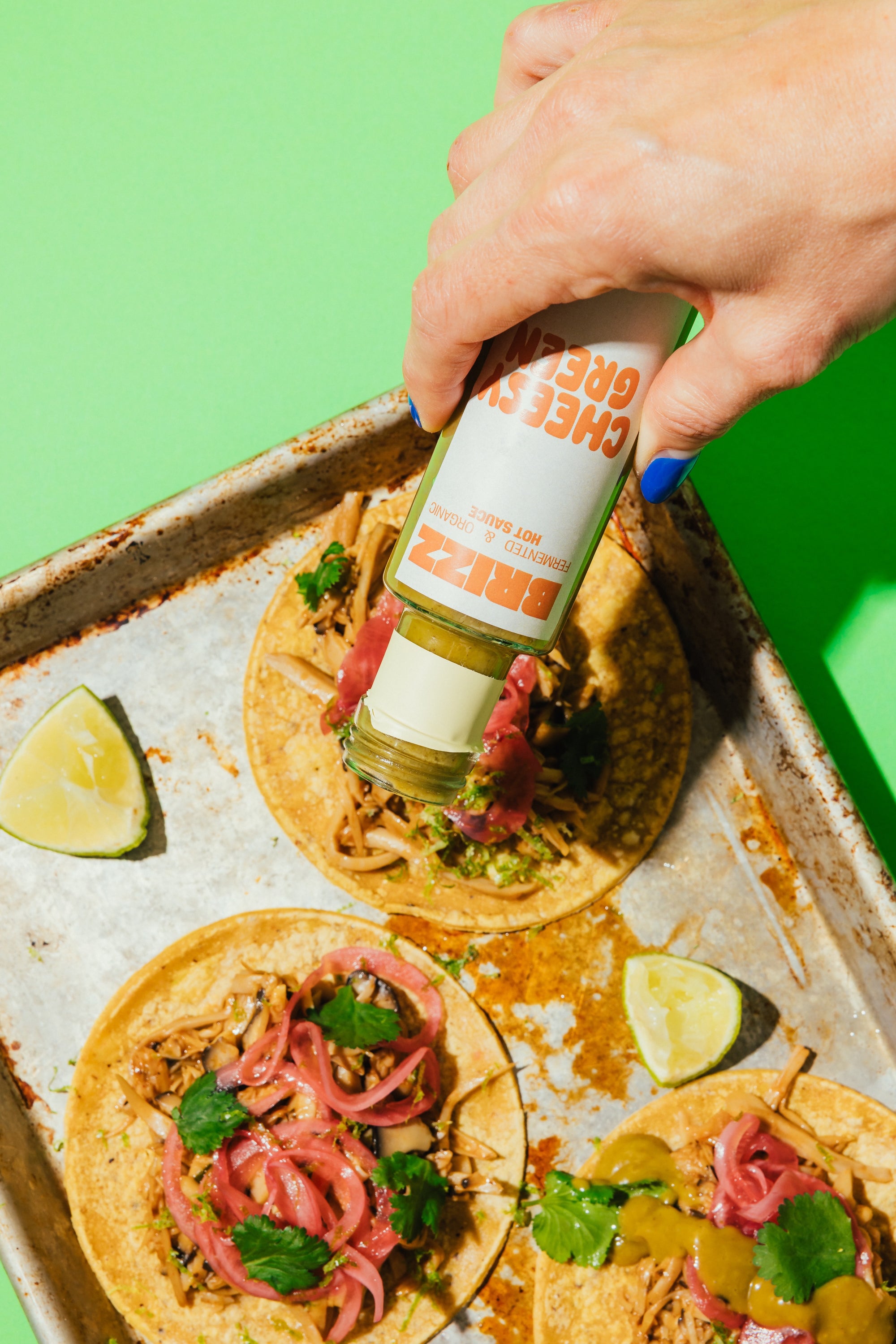 Tacos mit BRIZZ Cheesy Green Sauce beträufelt – Bio, mild-scharf, mit Jalapeño.