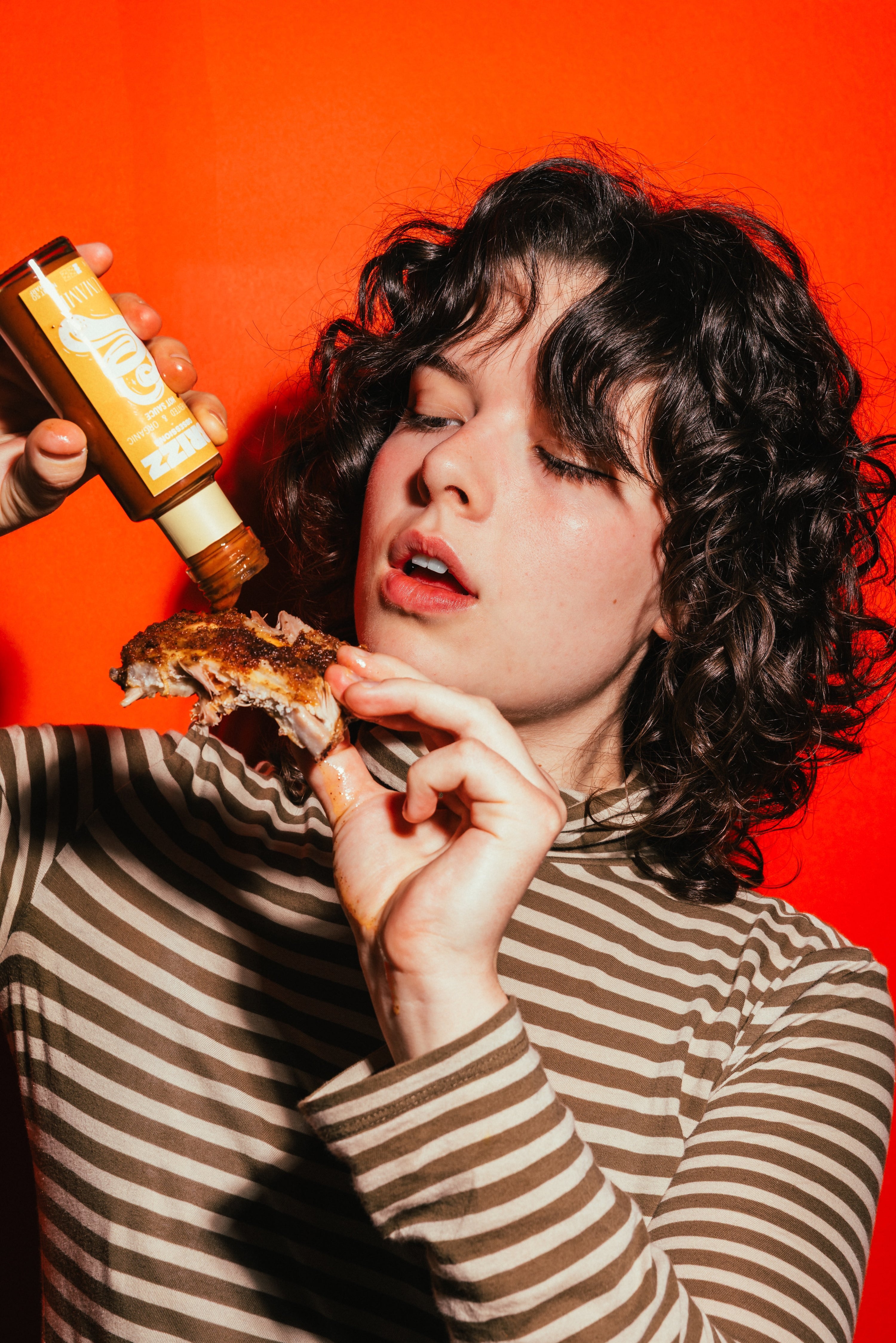 Person genießt BRIZZ Umami Sauce mit Spareribs – nachhaltig, fermentiert, voller Geschmackstiefe.